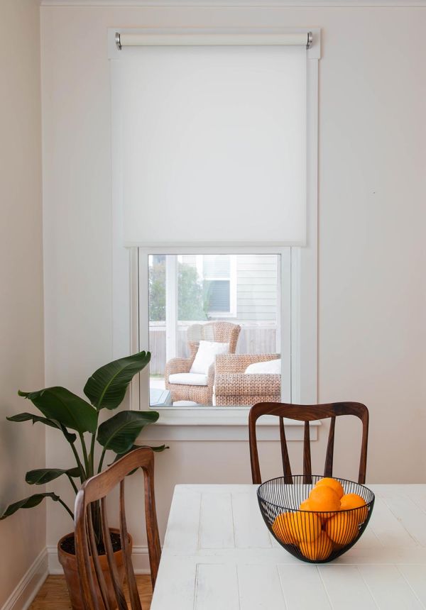 Dining room with motorized window shade partially lowered